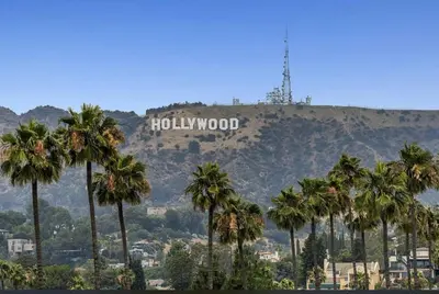 a hollywood sign on top of a mountain with palm trees at Hollywood Apartments Mario & No Themed With Pool FREE parking and WIFI in Los Angeles