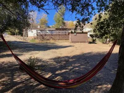 a hammock hanging from a tree in a yard at Shirley Creek Retreat: a Mountain Oasis in Wofford Heights