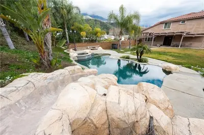 a swimming pool with rocks in a yard at Private-room-Private-entrance-spectacular-city-landscape-views-from-room in Rancho Cucamonga