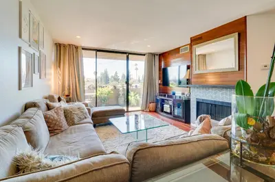 a living room with a couch and a table at Granada Hills Condo with Community Pool and Workspace in Los Angeles