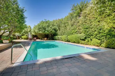 a swimming pool in a yard with trees at Granada Hills Condo with Community Pool and Workspace in Los Angeles