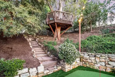 a tree house in the middle of a garden at Modern Family Farmhouse with Pool, Jacuzzi, Putting Green, Treehouse, Bocce and more in Thousand Oaks