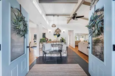 a hallway with a living room with a ceiling fan at Modern Family Farmhouse with Pool, Jacuzzi, Putting Green, Treehouse, Bocce and more in Thousand Oaks