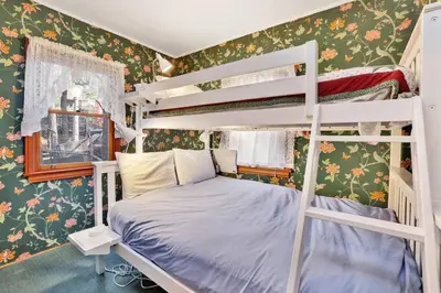 a bedroom with two bunk beds and floral wallpaper at Temple Lake Views Walk To Marina & Village Cabin in Big Bear Lake