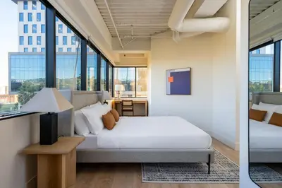 a bedroom with a bed and large windows at Kasa Sunset Los Angeles in Los Angeles
