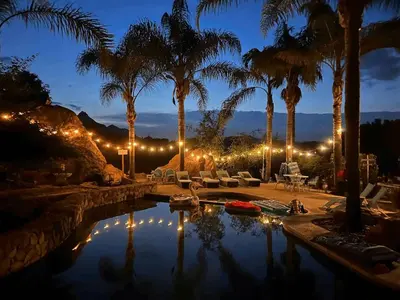 a pool with palm trees and chairs and lights at The Malibu Retreat Guest House - Salt Water Pool & Jacuzzi, Nature Oasis in Calabasas