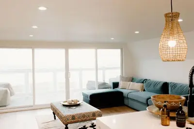 a living room with a couch and a table at Oceanfront Penthouse On Sand - Epic Views/Sunsets! in Huntington Beach