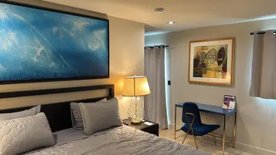 a bedroom with a bed and a desk and a large painting at Art District Downtown Spacious Homes in Los Angeles