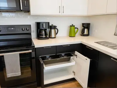 a kitchen with black appliances and white cabinets at Art District Downtown Spacious Homes in Los Angeles