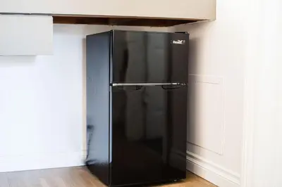 a black refrigerator in the corner of a kitchen at Big Bear Spa Suites in Big Bear Lake