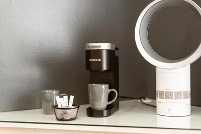 a coffee maker and two cups on a counter at Big Bear Spa Suites in Big Bear Lake