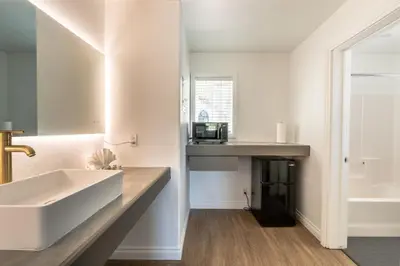 a bathroom with a white sink and a tub at Big Bear Spa Suites in Big Bear Lake