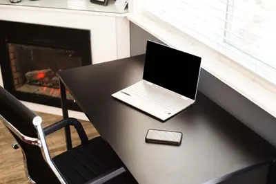 a laptop computer sitting on a table with a fireplace at Big Bear Spa Suites in Big Bear Lake
