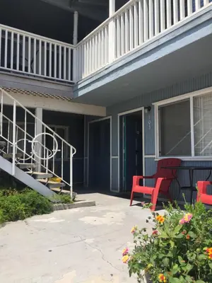 a porch with two red chairs on a house at The Shores Inn in Ventura