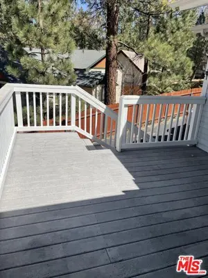 a wooden deck with a white railing on a house at Paramount Paradise in Big Bear Lake