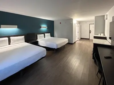a hotel room with two beds and a desk at Studio 6 Suites Carson, CA in Carson