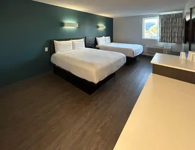 a hotel room with two beds and a sink at Studio 6 Suites Carson, CA in Carson