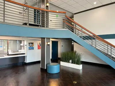 a staircase in a building with a blue stool at Studio 6 Suites Carson, CA in Carson
