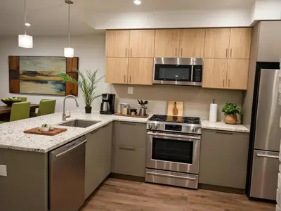 a kitchen with stainless steel appliances and wooden cabinets at Glamorous KTown Boutique Residences with Rooftop view in Los Angeles