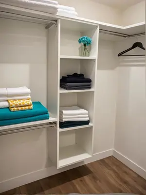 a walk in closet with white shelves and towels at Glamorous KTown Boutique Residences with Rooftop view in Los Angeles