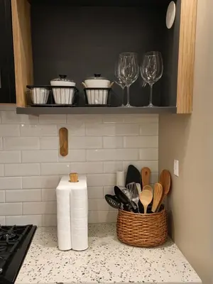 a kitchen counter with a basket of utensils and wine glasses at Glamorous KTown Boutique Residences with Rooftop view in Los Angeles