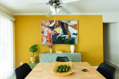 a dining room with a table and a yellow wall at Lovely and cozy apartment- Rancho in Rancho Palos Verdes