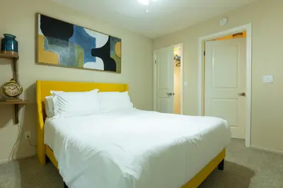 a bedroom with a white bed and a painting on the wall at Lovely and cozy apartment- Rancho in Rancho Palos Verdes