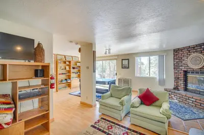 a living room with two chairs and a fireplace at Quaint Big Bear Home with Hot Tub 4 Mi to Skiing! in Big Bear City