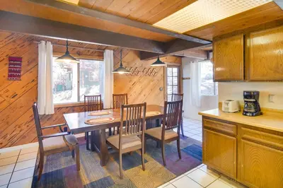 a kitchen and dining room with a table and chairs at Quaint Big Bear Home with Hot Tub 4 Mi to Skiing! in Big Bear City