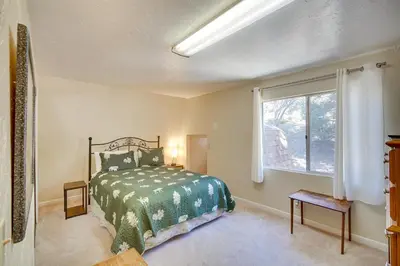 a bedroom with a bed and a window at Quaint Big Bear Home with Hot Tub 4 Mi to Skiing! in Big Bear City