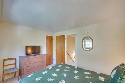 a bedroom with a television and a dresser with a bed at Quaint Big Bear Home with Hot Tub 4 Mi to Skiing! in Big Bear City