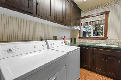 a kitchen with a washer and dryer in it at Big Bear Villa - Walk to Lake ad Village! Hot Tub, Jet Tub and so much more! in Big Bear Lake