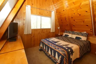 a bedroom with a bed and a television in a cabin at Kapers - Located in a beautiful quiet area of Big Bear Lake, walking distance to Snow Summit! in Big Bear Lake