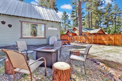 a backyard with chairs and a grill and a fence at The Weekender- Adorable Modern Chic Cottage in Big Bear City