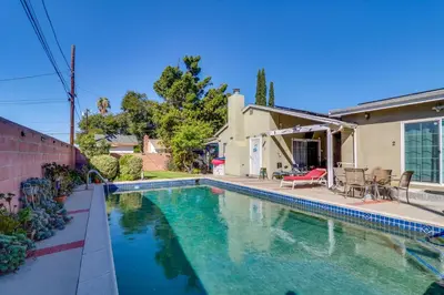a swimming pool in front of a house at North Hills Home with Outdoor Entertaining Space in North Hills