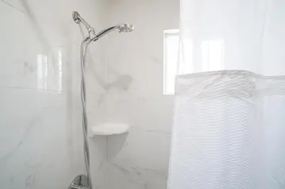 a bathroom with a shower with a shower curtain at SIGNAL HILL MOTEL BEACH MOTEL in Long Beach