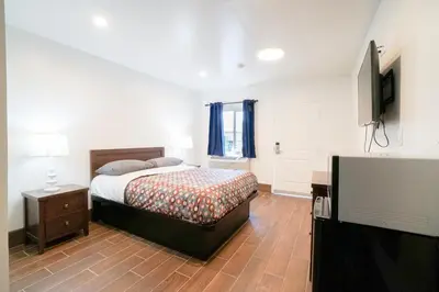 a bedroom with a bed and a flat screen tv at SIGNAL HILL MOTEL BEACH MOTEL in Long Beach