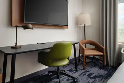 a room with a desk and a chair and a tv at Fairfield by Marriott Inn & Suites Barstow in Barstow