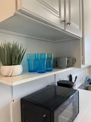 a kitchen with a counter with blue bowls and a microwave at Spacious Studio close to LAX and close to beaches! in Gardena