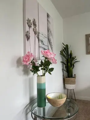 a glass table with two vases with flowers on it at Spacious Studio close to LAX and close to beaches! in Gardena