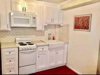 a kitchen with white cabinets and a white stove top oven at Echo Park Studio Oasis with Modern Comforts in Los Angeles