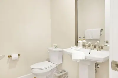 a white bathroom with a toilet and a sink at The Pines Retreat- Impeccable Modern Village Chalet in Big Bear Lake