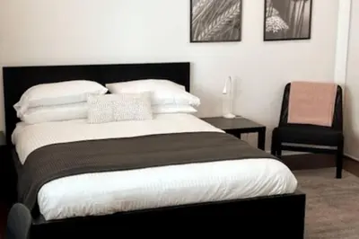 a bedroom with a black and white bed and a chair at House on The Beach in Los Angeles