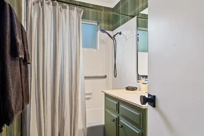 a bathroom with a shower curtain and a sink at Romantic & Family Friendly Chalet In The Woods in Lake Arrowhead