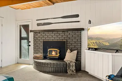 a fireplace in a living room with a view at Romantic & Family Friendly Chalet In The Woods in Lake Arrowhead