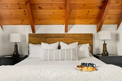 a bedroom with a bed with a bowl of fruit on it at Romantic & Family Friendly Chalet In The Woods in Lake Arrowhead
