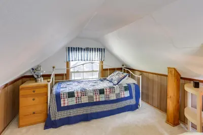 a attic bedroom with a bed and a window at Crestline Cabin Close to Lake Arrowhead and Skiing in Crestline
