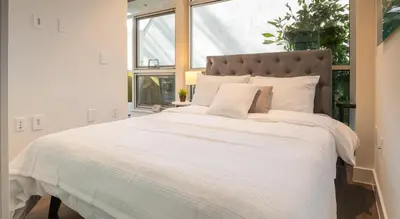 a bedroom with a large white bed with a window at Stylish Condo By The Beach in Los Angeles