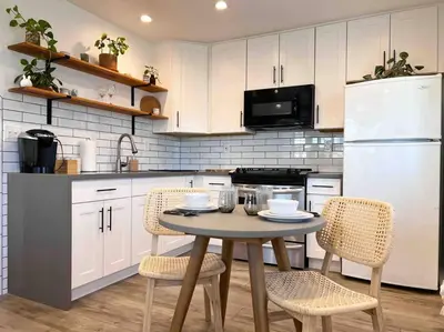 a kitchen with a table and chairs and a white refrigerator at The Cozy Oasis - A Renovated and Modern Studio near LAX + SoFi + Beaches + Freeway in Lawndale