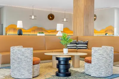 a lobby with a couch and a table and chairs at Cambria Hotel Burbank Airport in Burbank